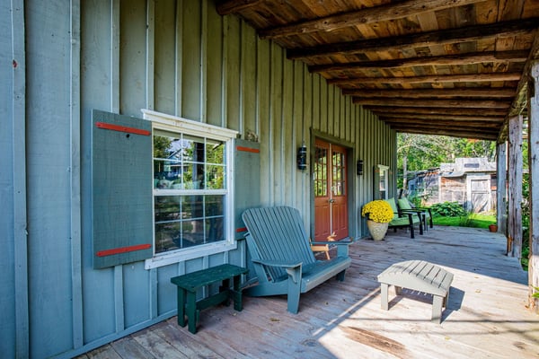 Rustic log cabin recreation room with foosball table, bar seating, exposed wooden beams, and kitchen area